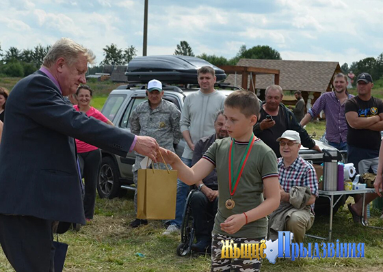 На снимке: Юрий Осипов вручает сладкие призы юным участникам соревнований.